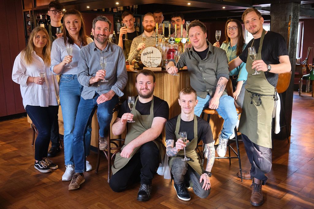 Best Sussex Pub BRAVO 2024 - Eight Bells Jevington near Eastbourne. Located on the South Downs, Phil, Josh and their team are voted the best Sussex pub in East and West Sussex. Here they are pictured in their main pub area, showcasing the award.