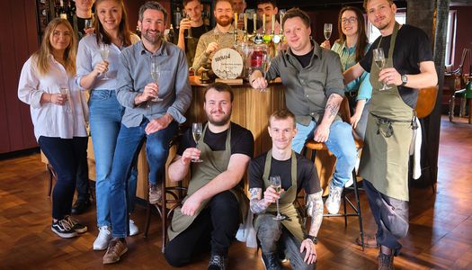 Best Sussex Pub BRAVO 2024 - Eight Bells Jevington near Eastbourne. Located on the South Downs, Phil, Josh and their team are voted the best Sussex pub in East and West Sussex. Here they are pictured in their main pub area, showcasing the award.
