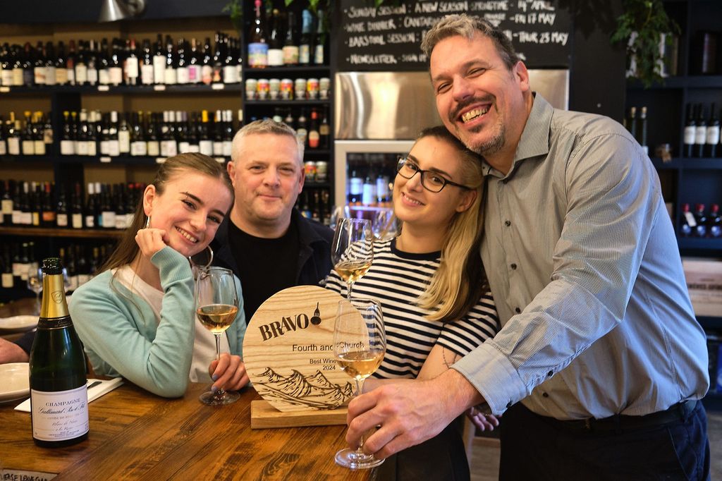 Fourth and Church - Best Wine List in Brighton and Hove in 2024 - BRAVO winners. Pictured, Paul Morgan and his team celebrating the win against a back drop of wine bottles at Fourth and Church on Church Road in Hove