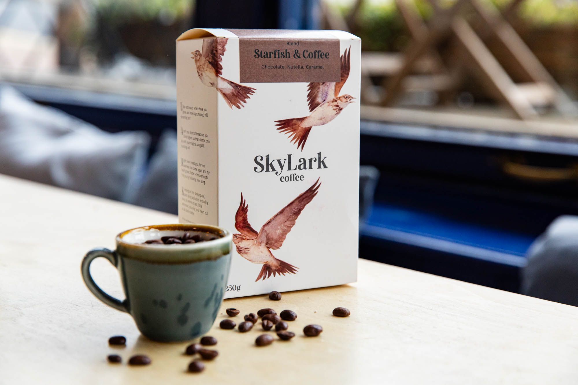 box of skylark coffee with small cup with coffee seeds inside