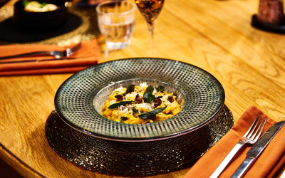 A ceramic dish with a risotto and a glass of wine at Terra Restaurant, Tottington Manor.