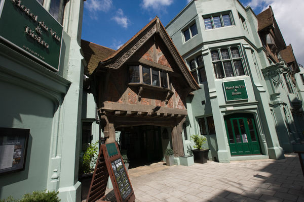 The exterior of Hotel Du Vin Brighton. It''s an old building with a tudor esque section. The Majority of the building is a nice light green. 
