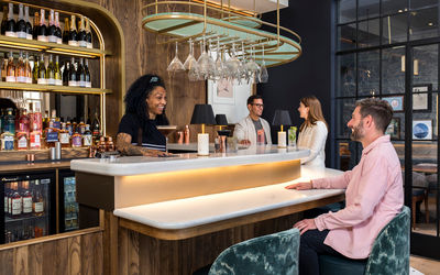 Man sat at bar and waitress serving a