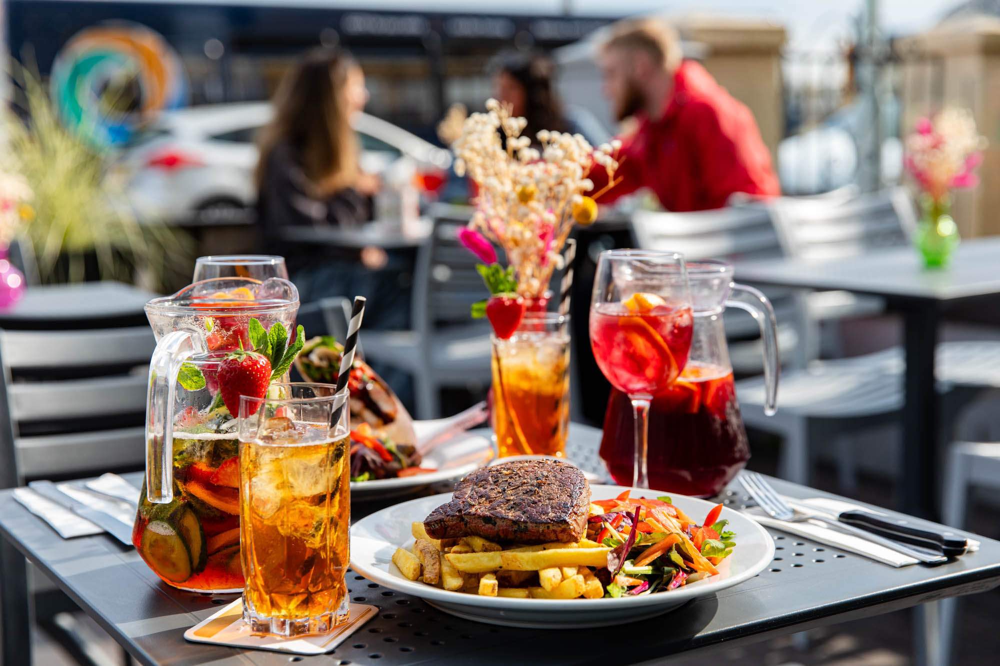 side shot of the chips and steak served with drinks on the terrace table at Beach House