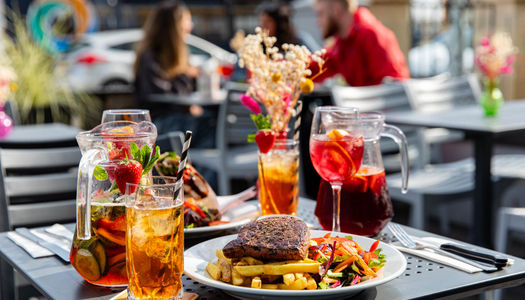 side shot of the chips and steak served with drinks on the terrace table at Beach House