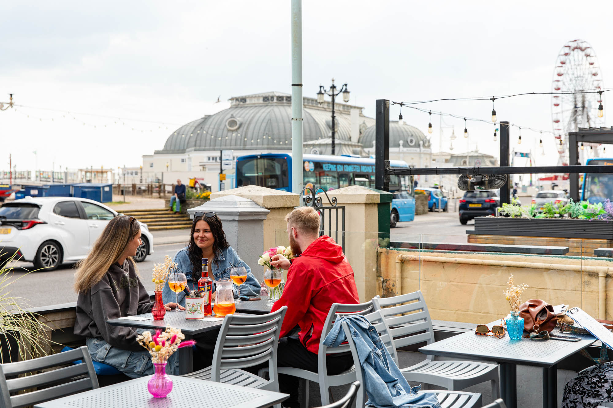 three friends having drinks and food at the Beach House terrace