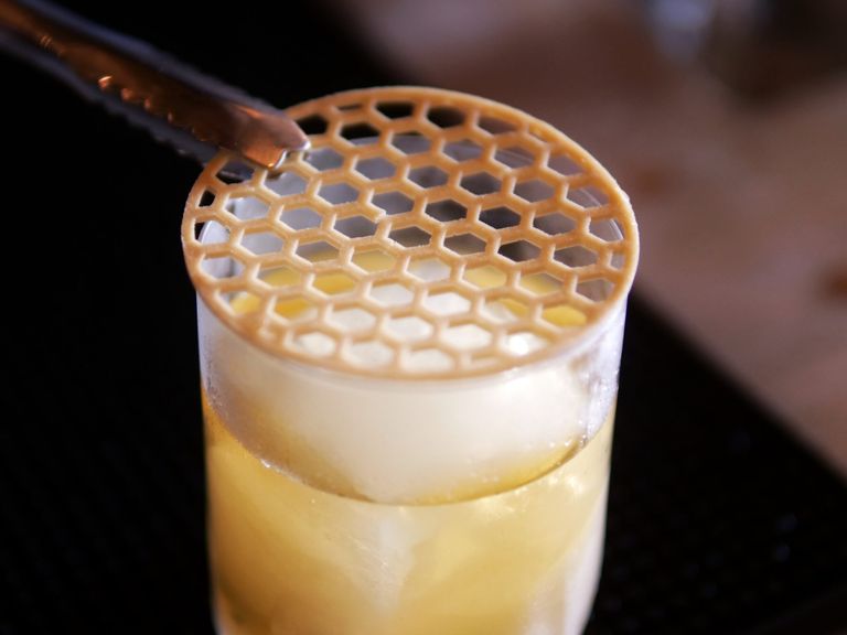 A honey cocktail with a bee cells garnish.