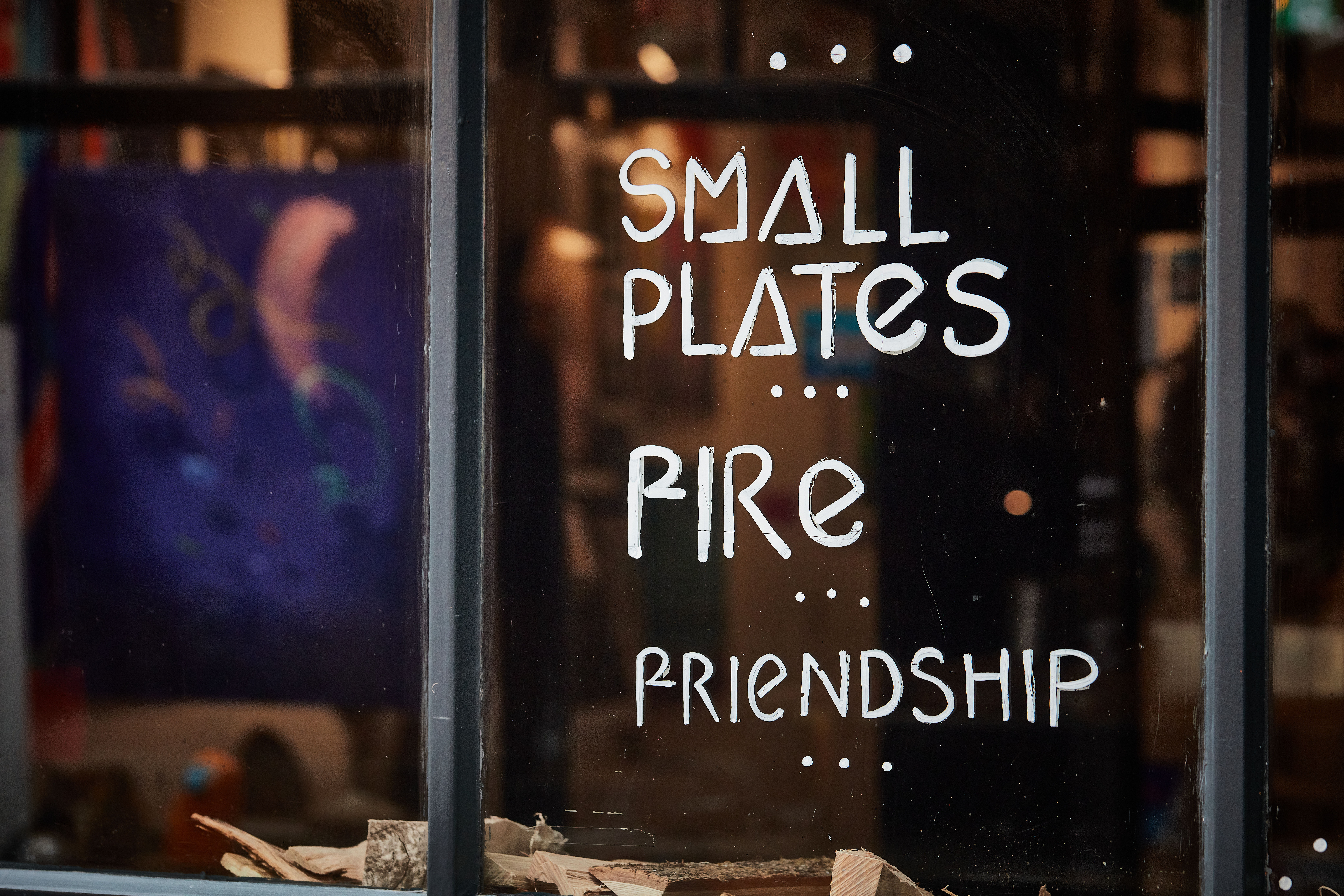 writing on the window which describes small plates, friendship and fire