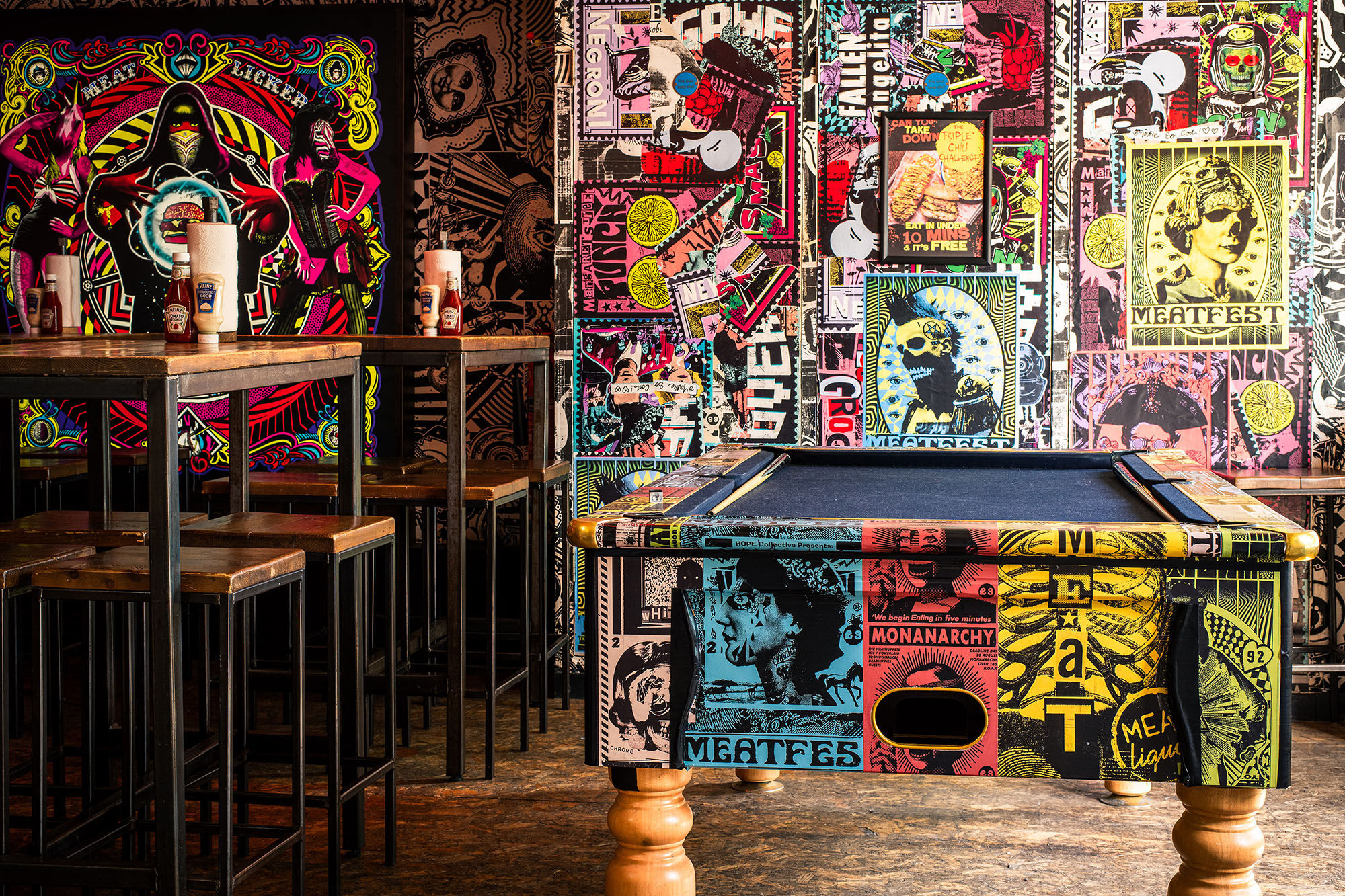 The pool table at MEATliquor with posters on the walls.