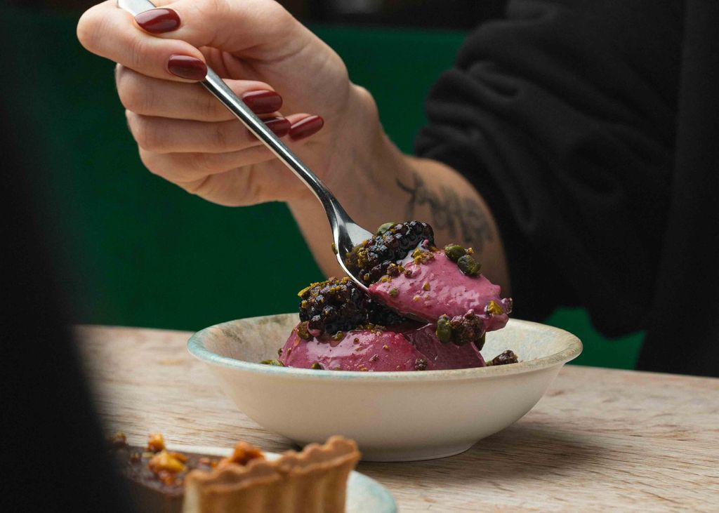 hand holding spoon with the piece of dessert on ti