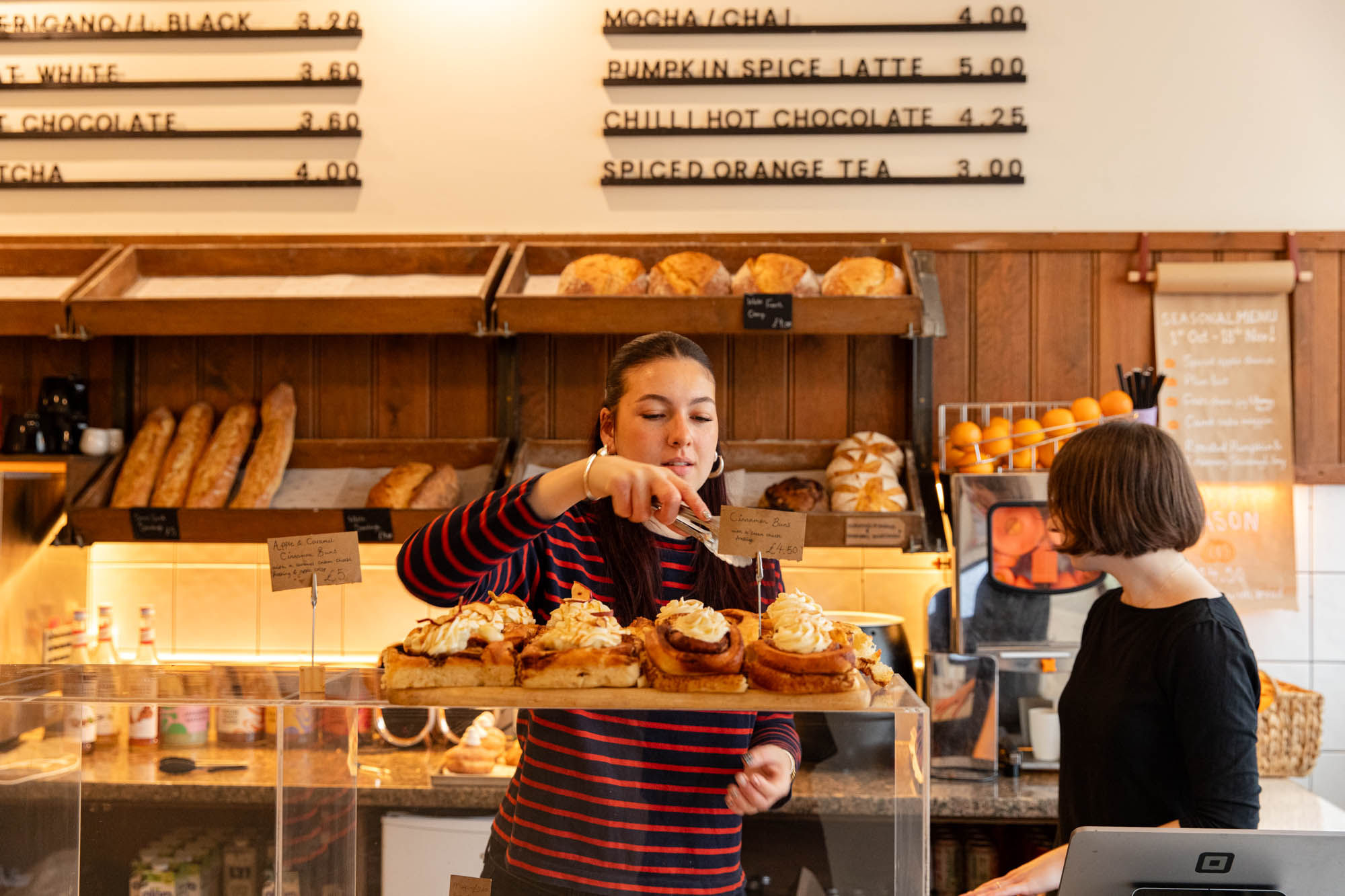 lady at the bayon bakery adding pasty to the bag