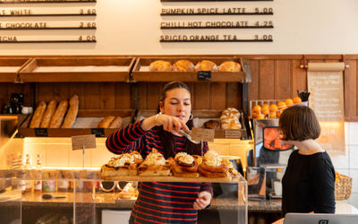 lady at the bayon bakery adding pasty to the bag