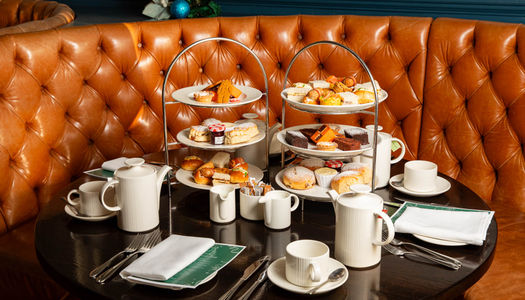 shot of the afternoon tea trays with cakes and cups of tea