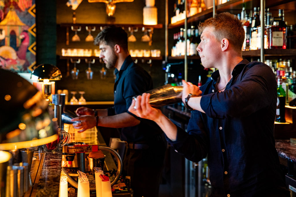 A bar tender making cocktails behind the bar. Photo by: Ellen Richardson