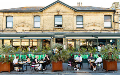 Outside Tapestry in Hove on a summer evening with people sitting outside. Photo by: Ellen Richardson