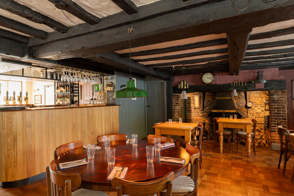 Interiors of a country pub with wooden furnishings and beams.