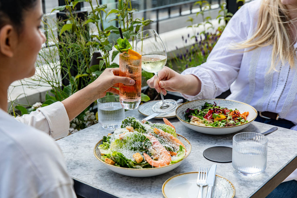 two ladies enjoying their dishes on the terrace of the Pearly Cow