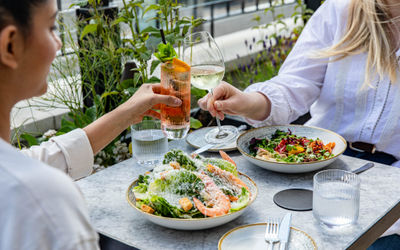 two ladies enjoying their dishes on the terrace of the Pearly Cow