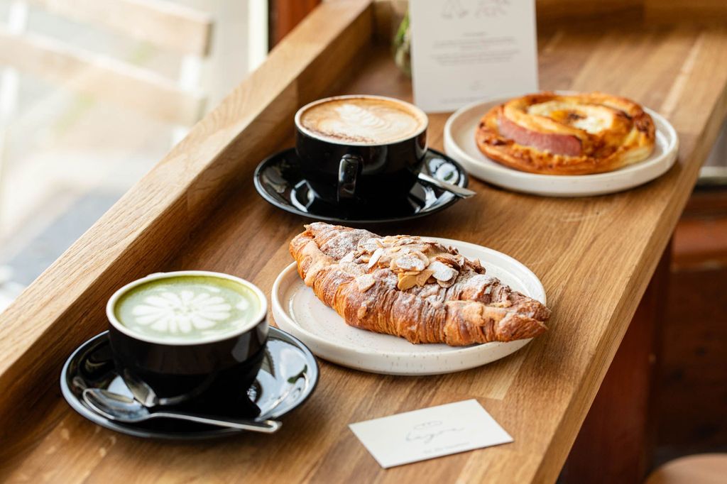 two flat white coffees with delicious looking pastry served at the table at Bayon Bakery