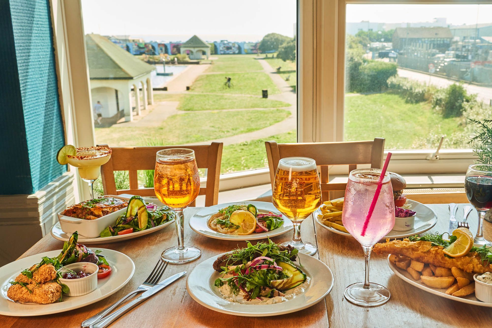 side shot of about 6 pub dishes and few drinks icnluding beer and fizz drinks at The Gather Inn