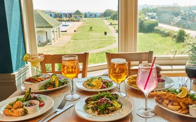 side shot of about 6 pub dishes and few drinks icnluding beer and fizz drinks at The Gather Inn