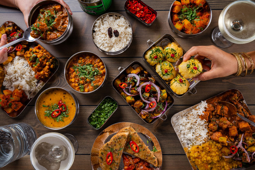 Christmas food at Mowgli Brighton. A selection of tiffins laid out with lots of colourful dishes at Mowgli street food Brighton. Indian restaurant Brighton guide