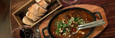 lamb stew served with bread and red wine