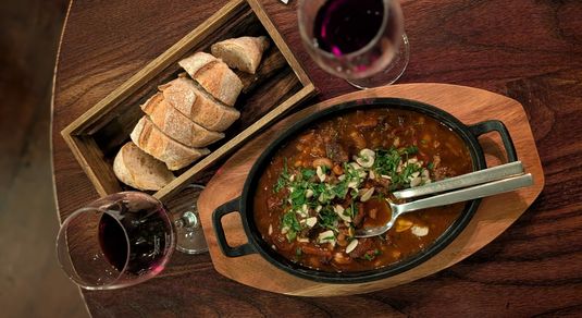 lamb stew served with bread and red wine
