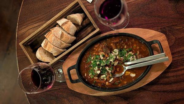 lamb stew served with bread and red wine