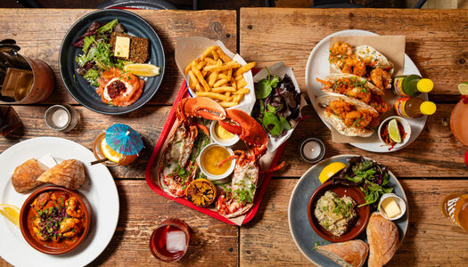 over head shot of the wooden table laid out with seafood dishes from Crabshack
