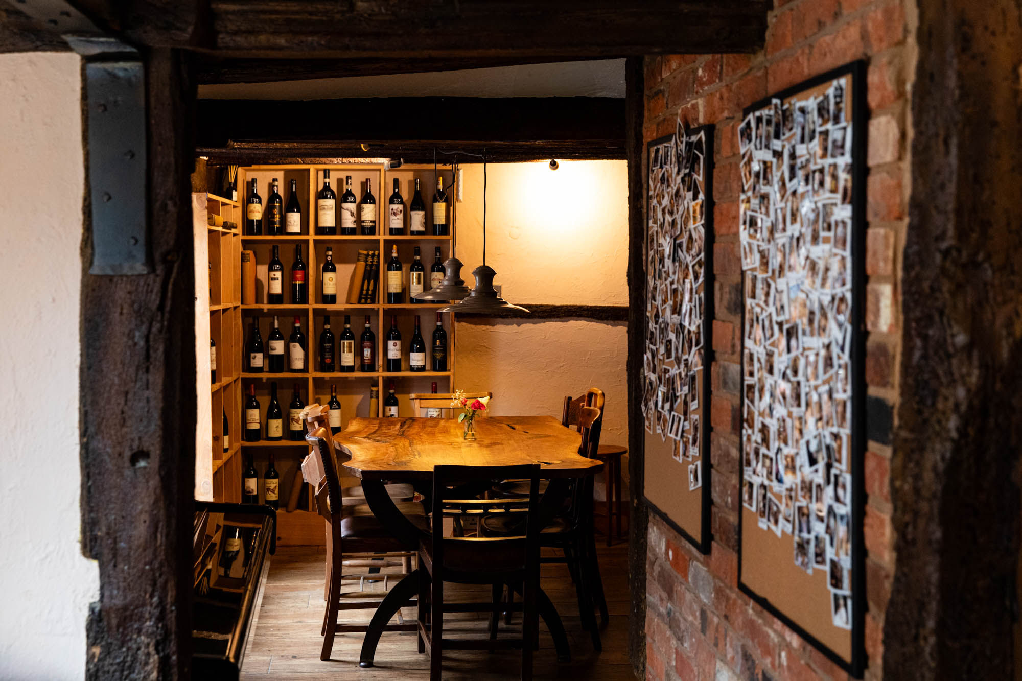 interior shot of the corner of Poco, wooden furniture walls and shelves with wines at Poco Alfriston