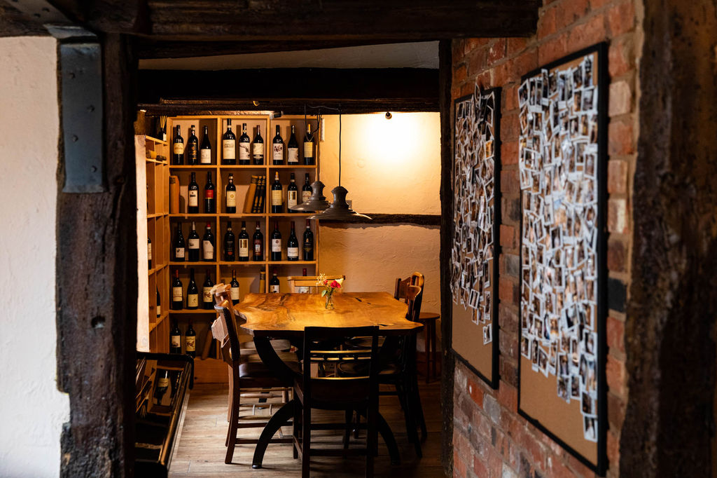 interior shot of the corner of Poco, wooden furniture walls and shelves with wines at Poco Alfriston