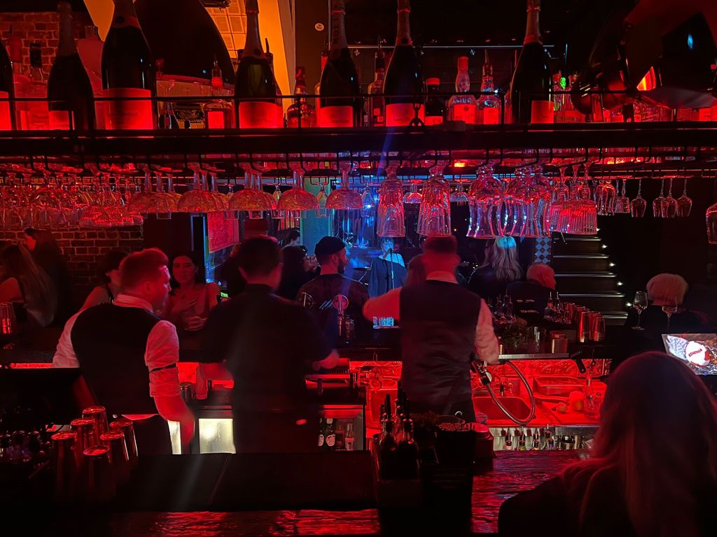 shot of the Bohemia bar in the evening, red light and bartenders making drinks on New Year's Eve in Brighton