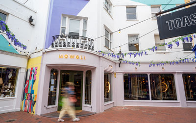 Mowgli Brighton on Dukes Lane with the pink exterior and gold lit signage.