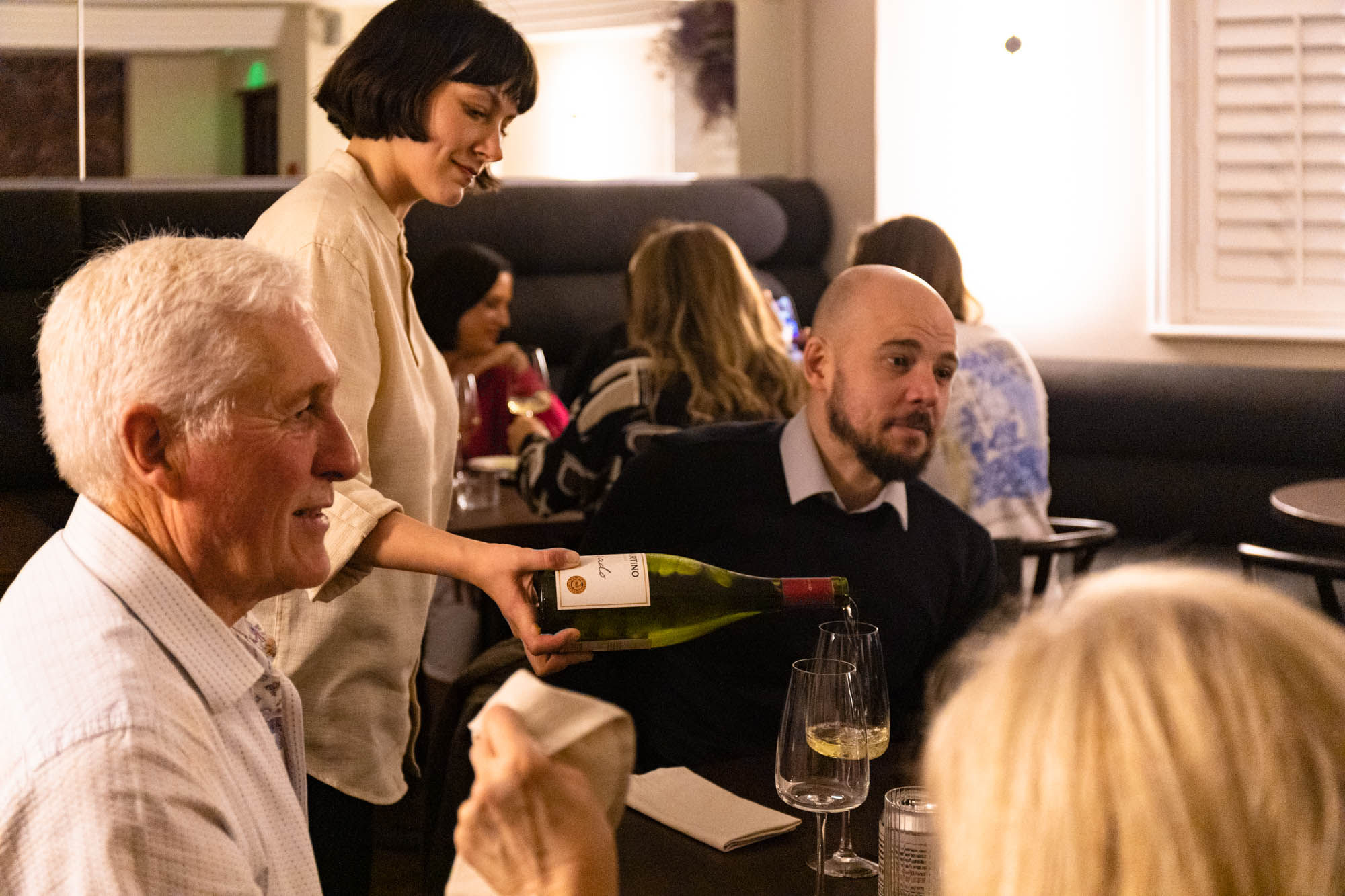 Pouring wine in a busy restaurant