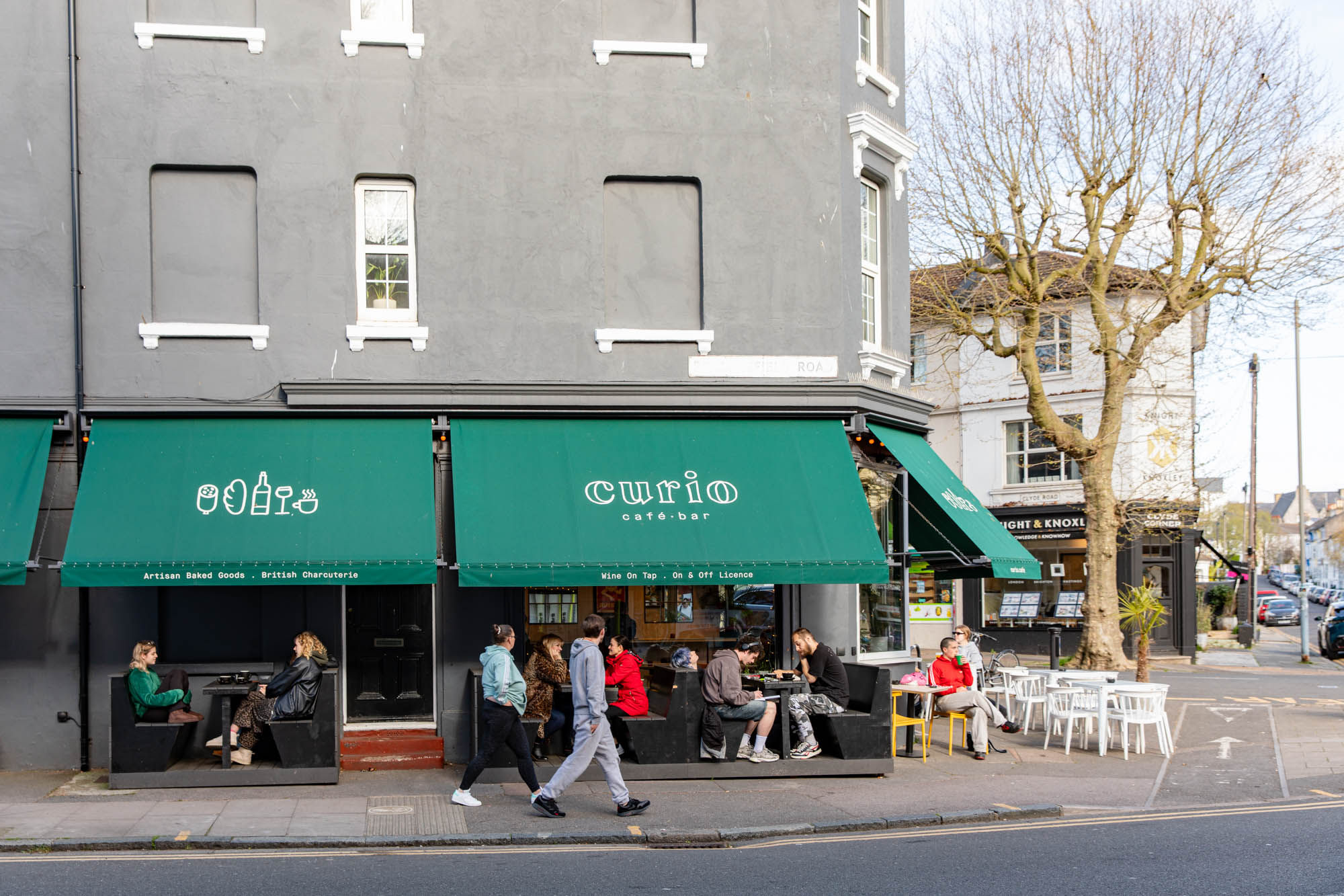 exterior shot of the Curio cafe and bar, people sitting in front of the venue and enjoying their food and drink