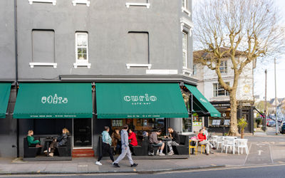 exterior shot of the Curio cafe and bar, people sitting in front of the venue and enjoying their food and drink
