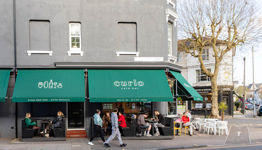 exterior shot of the Curio cafe and bar, people sitting in front of the venue and enjoying their food and drink