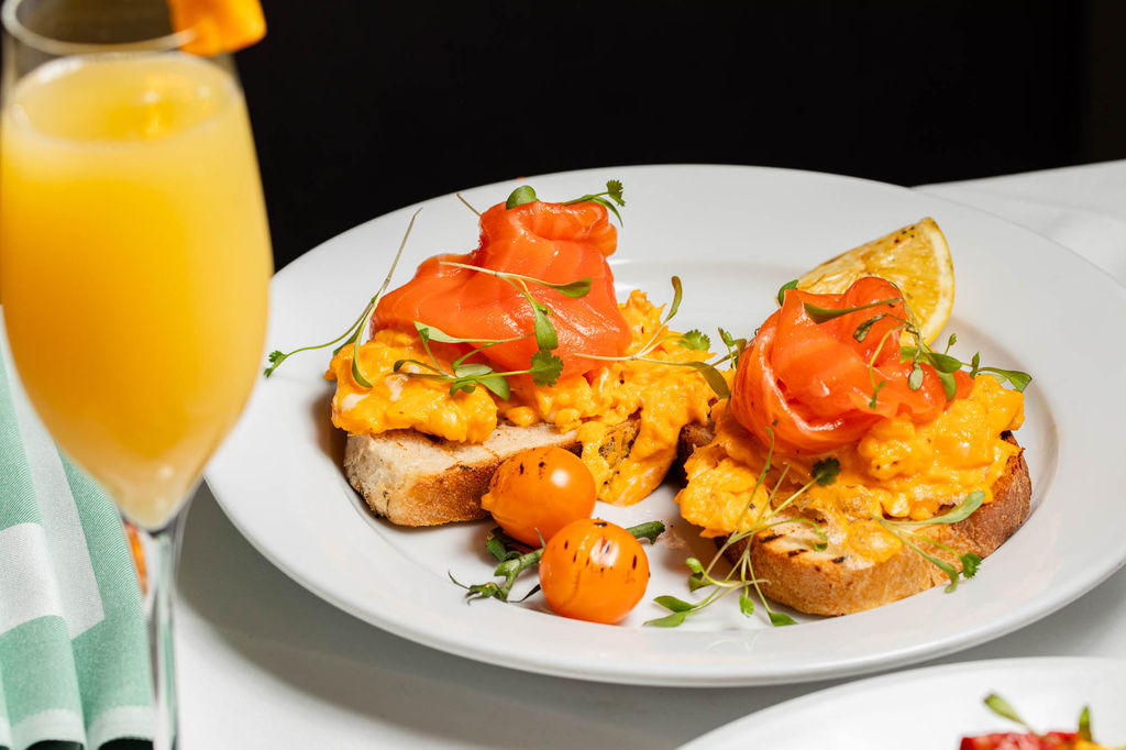 scrambled eggs served with cherries on the toast and with glass of orange juice