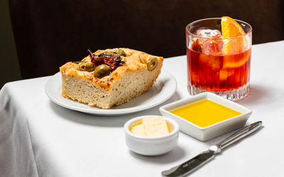 olive bread on the white plate served with butter and olive oli and cocktail