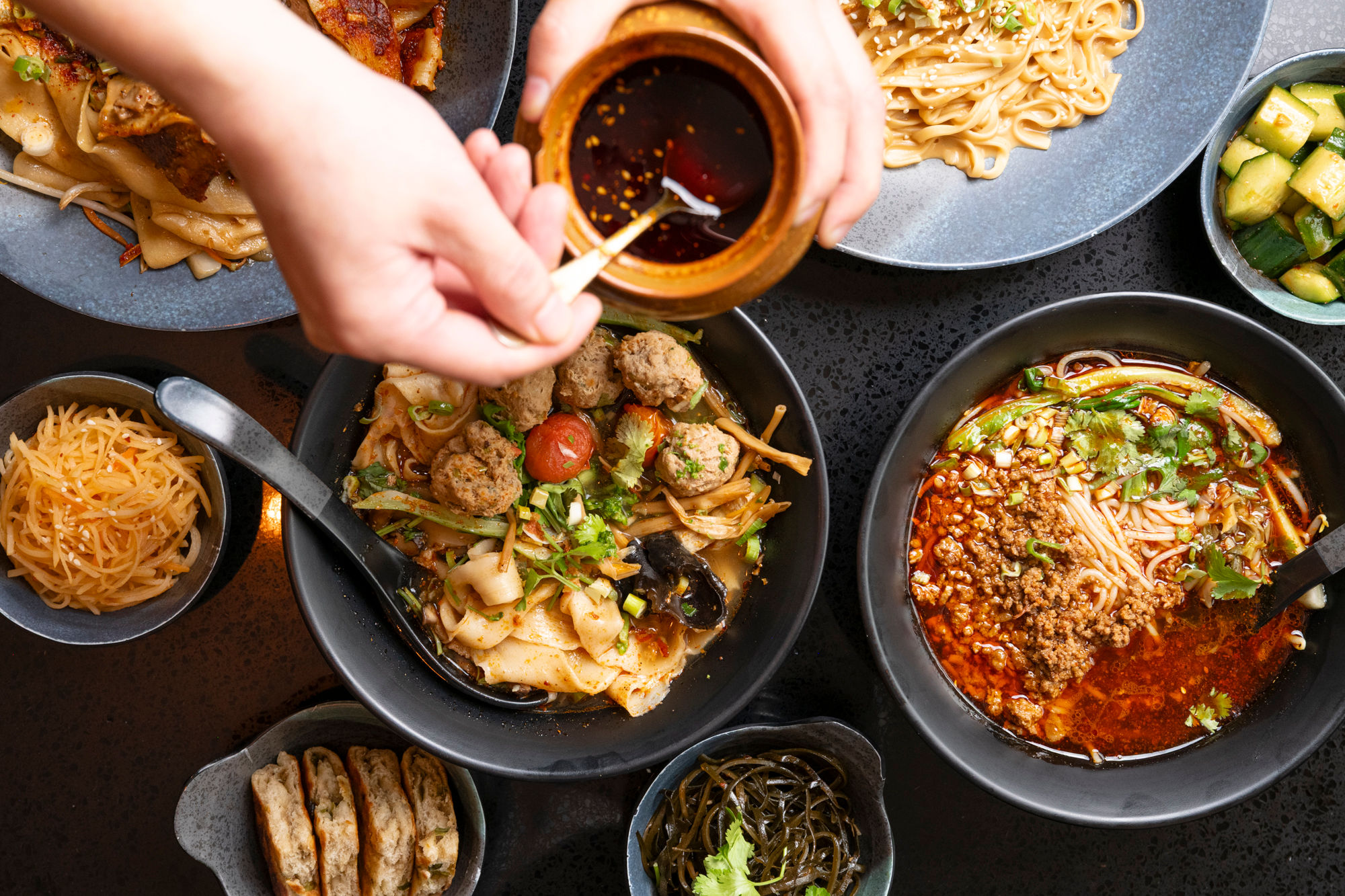 over head shot of the Shaanxi table laid out with few dishes, including noodles and meat dishes