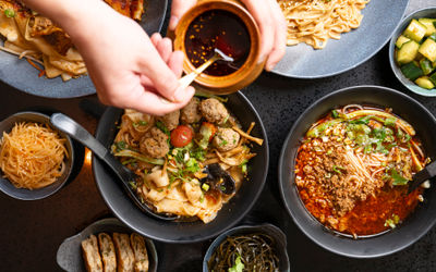 over head shot of the Shaanxi table laid out with few dishes, including noodles and meat dishes