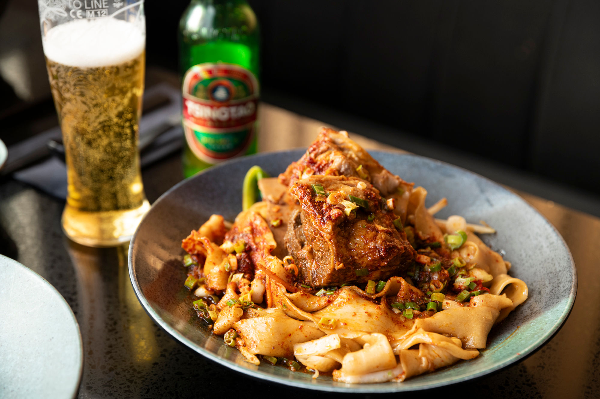close shot of the noodles with meat served with beer at Shaaxni brighton