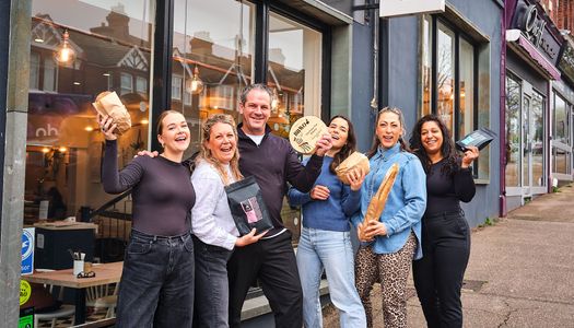The Flour Pot team in front of the venue celebrating their BRAVO Best Brew and Bakes win by holding the trophy and hands in the air