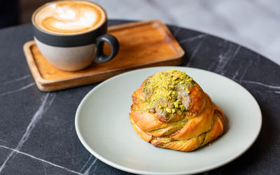 pistachio pastry served with flat white coffee