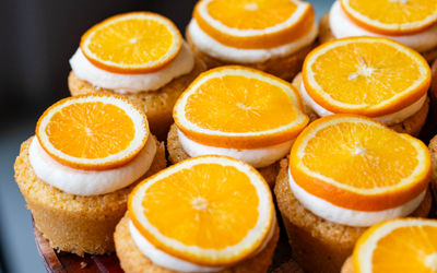 over head shot of the round cakes with icing and slice of orange at the top