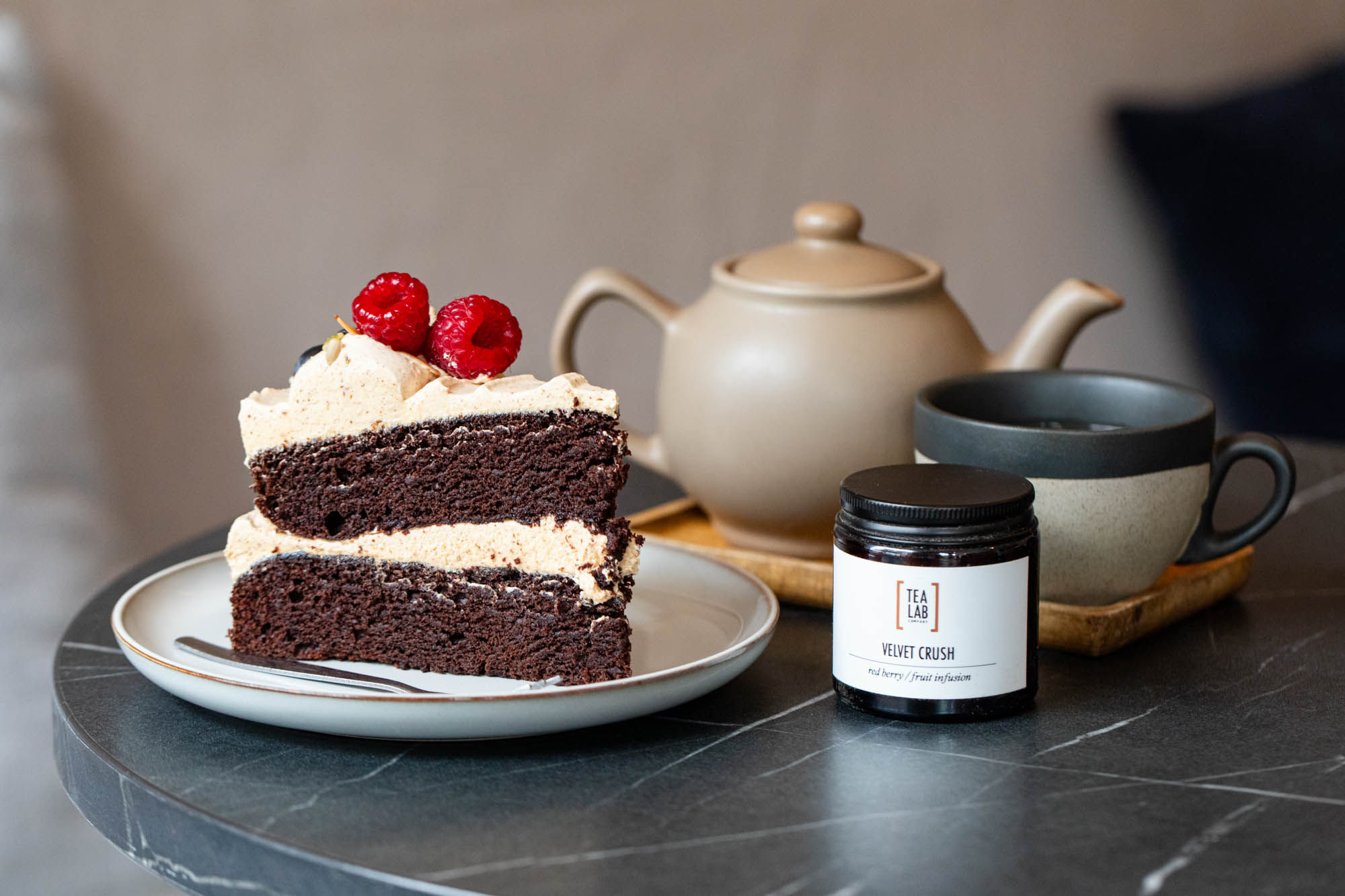 chocolate cake with raspberry served on the top together with tea