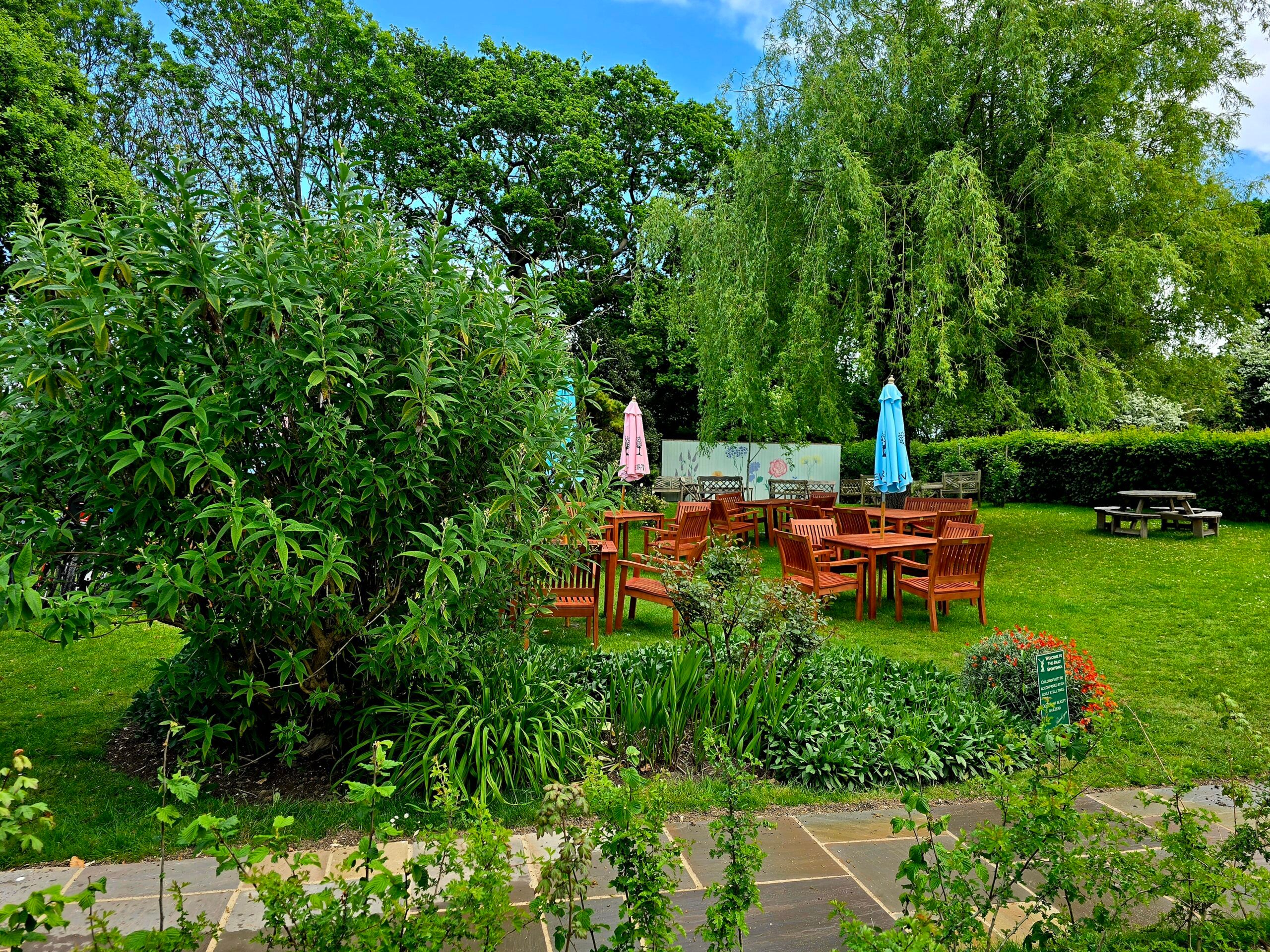 the Jolly Sportsman green garden with chairs and tables in the middle