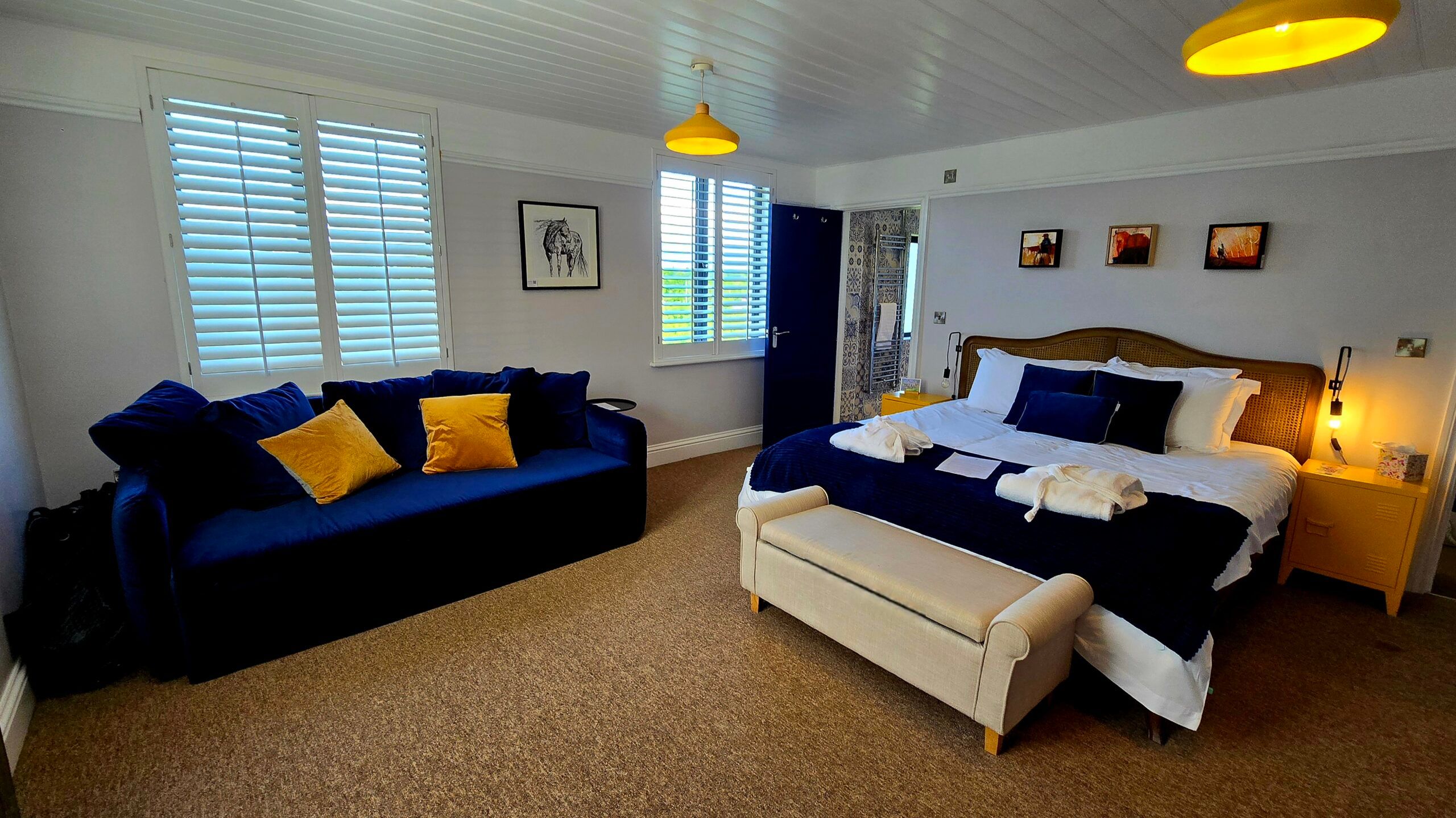 the Jolly Sportsman guest room, blue sofa with yellow pillows, bed with blue and white sheets