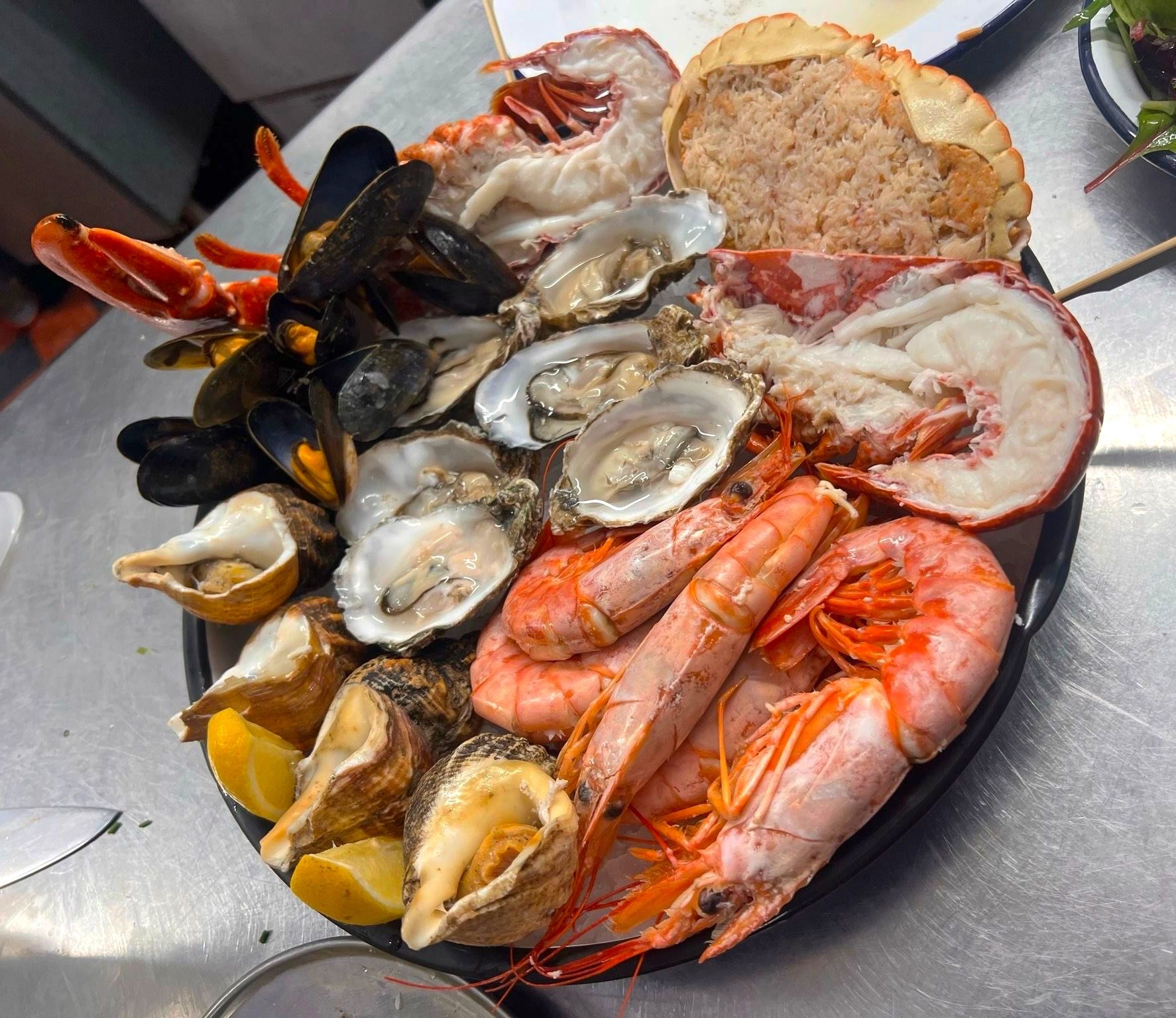 seafood platter with prawns, mussels, oysters, shrimp served on big black bowl at The Gothic Crab Brighton